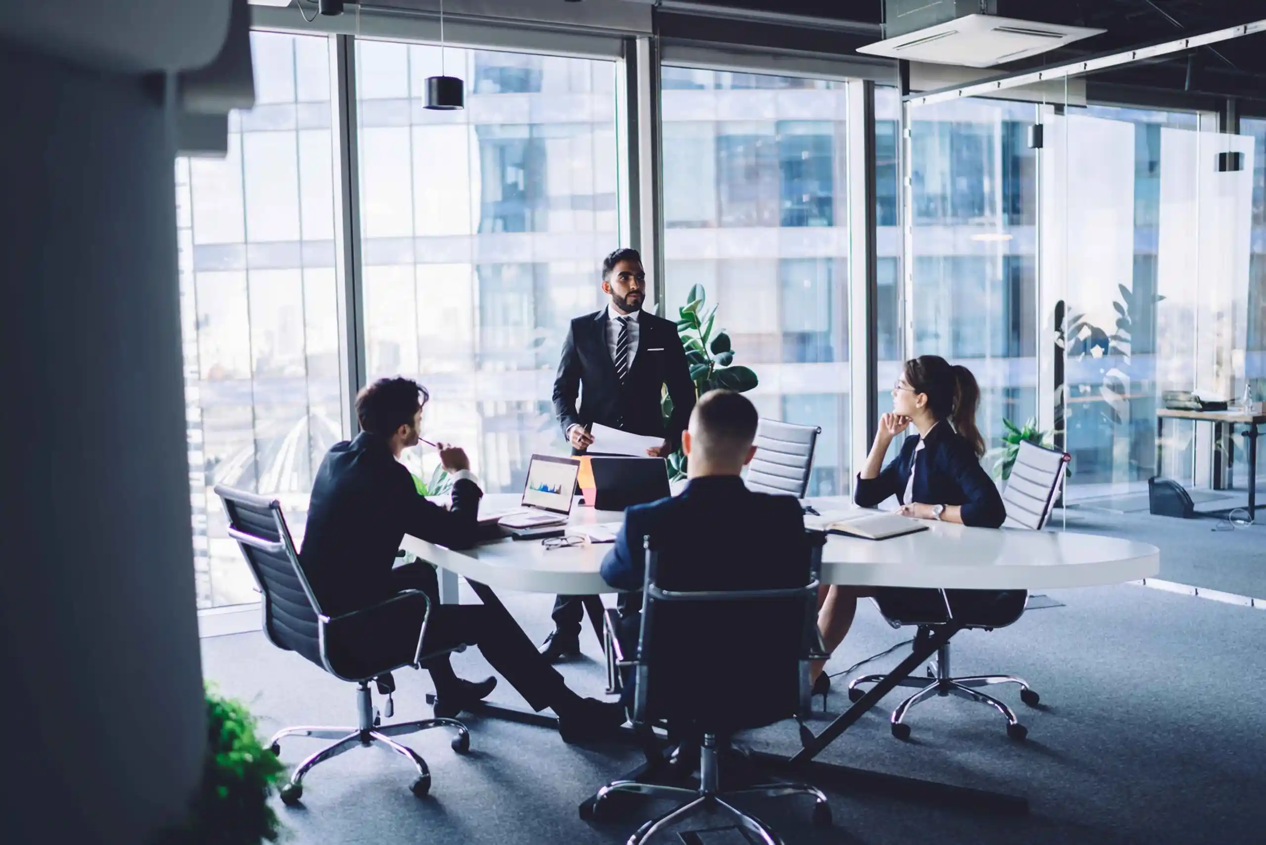 Business professionals discussing documents around a meeting table