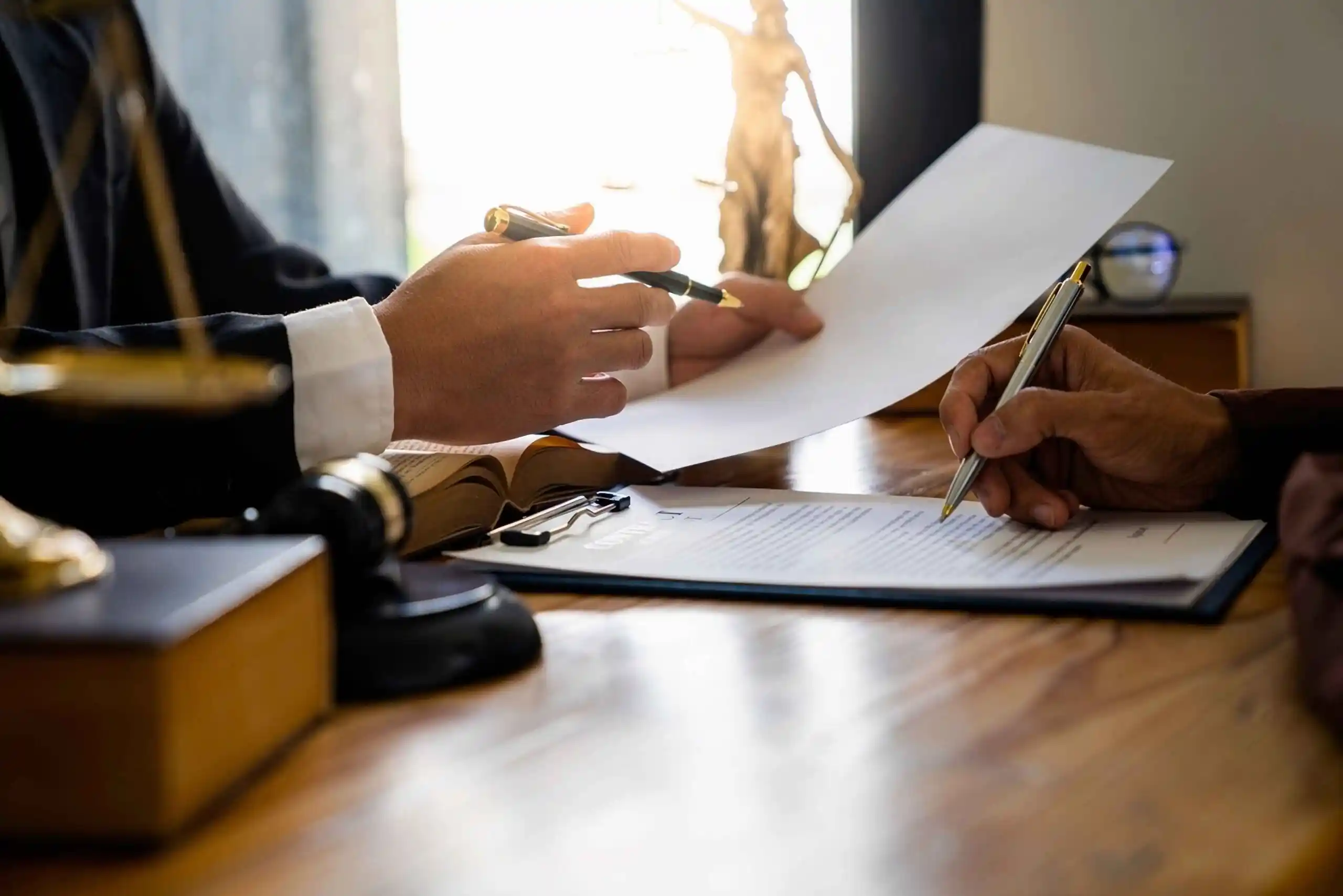 Two people reviewing and signing documents at a desk